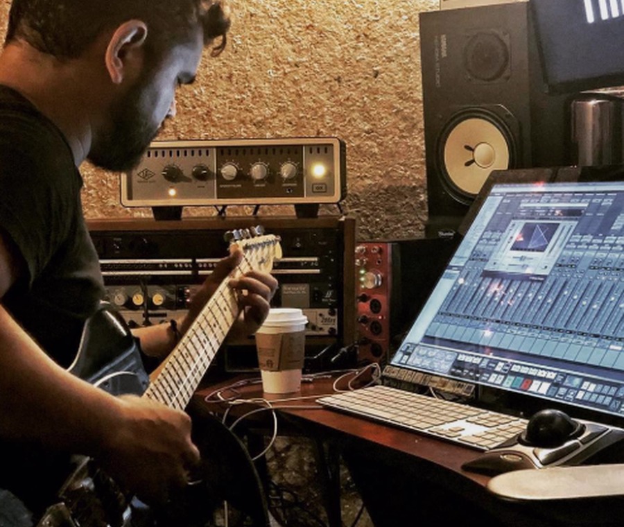 Preston Pope playing guitar in a recording studio